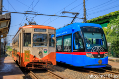 [万葉線六渡寺駅] 右・51列車MLRV1000形MLRV1004ドラえもんトラム、左・52列車、7070形7073令和号